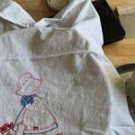 sourdough bowl covered with an embroidered tea towel