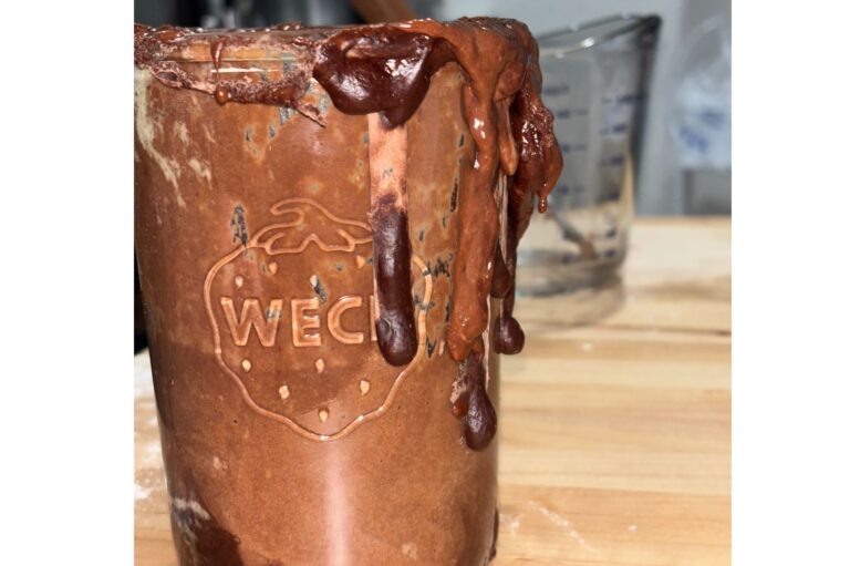 Active Chocolate Sourdough Starter in a glass jar that is dripping down the jar