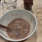 mixing chocolate sourdough starter with water with a dutch whisk