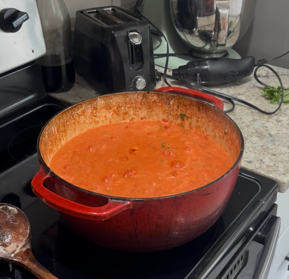 Homemade Tomato Soup on the stove in a red sauce pan
