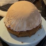 Ice cream on top of a homemade carrot cake on a baked Alaska